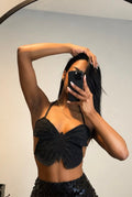 Person wearing a black sequin skirt and top in front of a neutral background